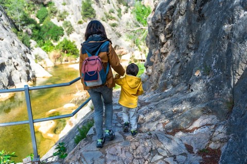 Mother and son walking along canaletes river in la fontcalda, a sanctuary located in gandesa,
