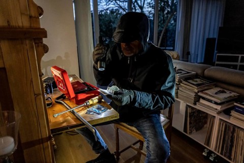 Symbolic image of a burglary, perpetrator has broken into a flat from the garden side and is