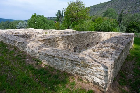 Old stone walls surrounded by lush greenery in a hilly landscape, Tatar bathhouse, Feredeu bath,