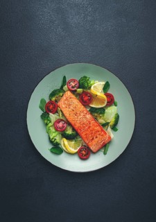 Grilled salmon fillet, with vegetables, broccoli, cherry, iceberg lettuce, spices and herbs,