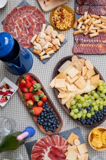 An inviting charcuterie board features assorted cheeses, cured meats, crackers, fresh strawberries,