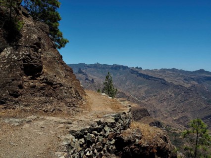 Rough trail along a rocky mountain landscape under clear skies, Altavista, Tamadaba Natural Park,