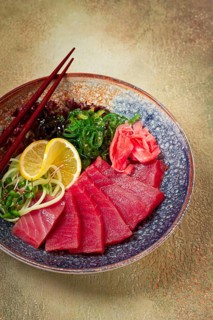 Tuna sashimi with daikon and wakame salad, pickled ginger, in a bowl