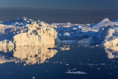 Icebergs and ice floes reflected in the water, summer, midnight sun, Jakobshavn glacier and ice