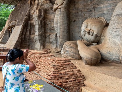 Praying woman in front of a reclining Buddha statue, Gal Vihara, Polonnaruwa, Sri Lanka