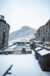 A picturesque village nestled in the mountains, with stone buildings and a snow blanketed