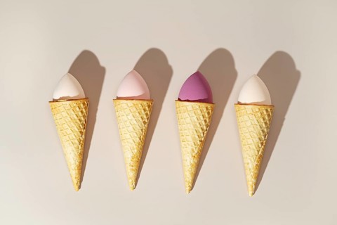 Cosmetic sponges styled creatively as ice cream scoops in waffle cones, showcasing a playful fusion