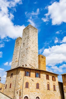 Towers of the old Town with historic buildings from Piazza del Duomo at San Gimignano on a sunny