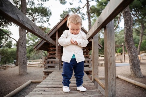 A young girl enjoys the peaceful surroundings of a forest park in the afternoon. She is immersed in