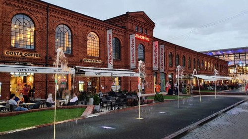 Red brick façade with shops and café. Water features at dusk, Manufaktura, Lódz, Lodz, Lodz, Poland