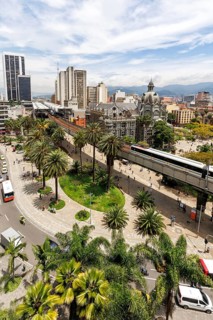Medellin skyline with a train of the Metro de Medellín at Plaza Botero in Medellin, Colombia