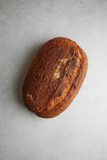 Top view of a freshly baked sourdough bread with a crispy crust and golden hue, perfectly textured
