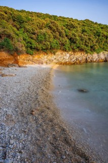 Crystal clear and turquoise water on the beach of Ustrine Bay on a sunny day at sunset on the