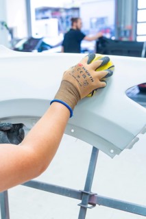 Person grinds a car part in a workshop with precision and craftsmanship, painter, Calw, Germany