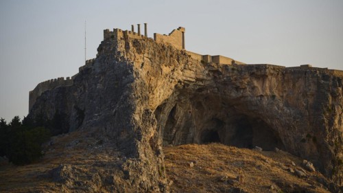An ancient castle on a rock during the golden hours of sunset, Acropolis of Lindos, Lindos, Rhodes,