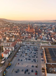 Aerial view of a town with a church in the centre, car parks and evening mood, Weil der Stadt,