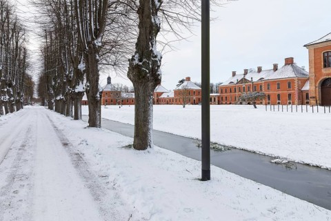 Snow-covered avenue, residential buildings and farm buildings of Bothmer Castle and the surrounding