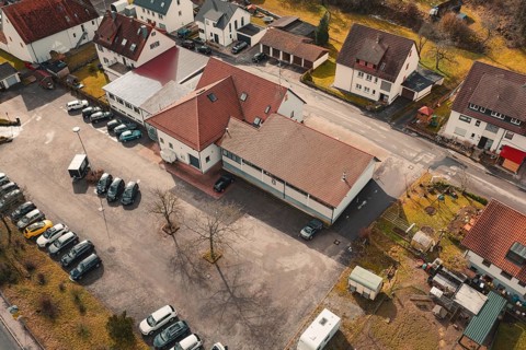 Aerial view of a village with buildings and parked cars in a quiet winter landscape, fire station,