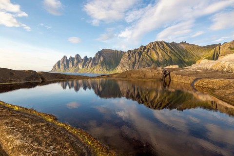 Crystal-clear reflection of the Okshornan mountain range in a large tide pool near Tungeneset,