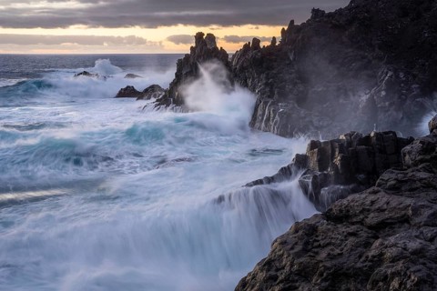 Waves break on the lava coast. In the evening. Charco Verde, La Palma, Canary Islands, Spain