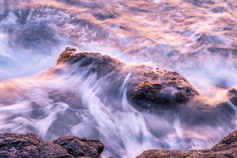 Rocks in the ocean, washed by waves. Long exposure, sunrise. La Palma, Canary Islands, Spain