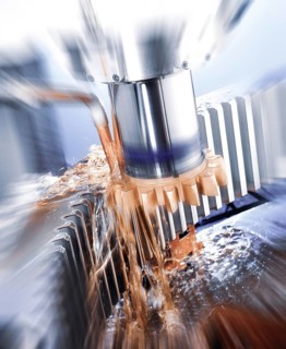 CNC controlled gear shaping machine precisely machining a metal gear with a vertical cutting tool,