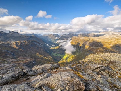 View of the valley of rocky hills where clouds cast shadows on the sunny landscapes, view of
