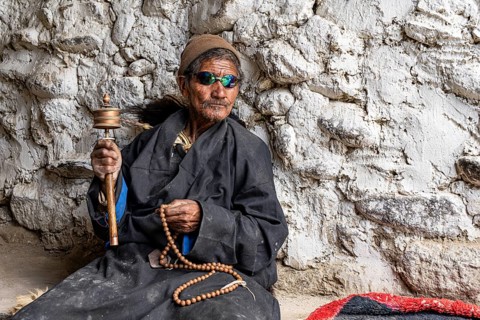 Elderly man wearing Buddhist stone mill and prayer necklace, Mala, in traditional dress, wearing