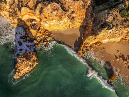 Drone top down view of Praia da Marinha beach in Algarve, Portugal, with ocean cliffs, sea stacks