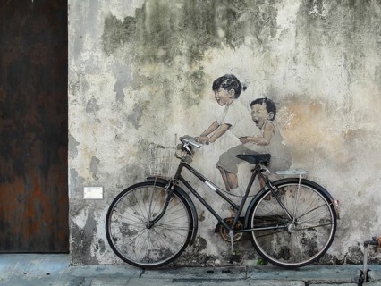 Little Children on a Bicycle street art on wall by Lithuanian artist Ernest Zacharevic in George