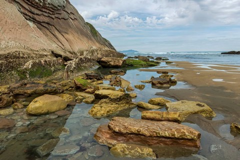 Distinctive rock cliffs as a geological formation of rock layers, Flysch on Itzurun Beach in