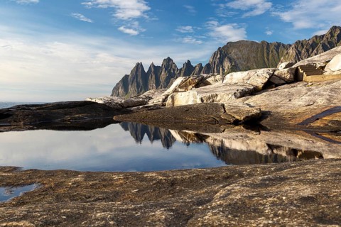 Perfect reflection of the Okshornan Mountains in the tide pool near Tungeneset on Senja, Norway