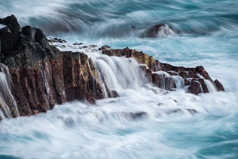 Lava rocks in the ocean, washed by waves. long exposure. Charco Verde, La Palma, Canary Islands,