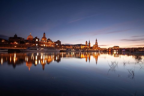 14 October 2021, illuminated historic skyline of Dresden reflected in the Elbe River at twilight,