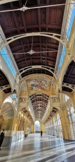 Impressive arcades with high ceilings, decorated with ornate frescoes. Elegant historical