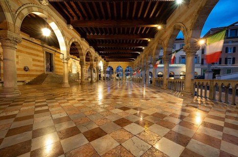 Illuminated Loggia del Lionello with Italian flags, blue hour, dramatic sky, old town, Udine,