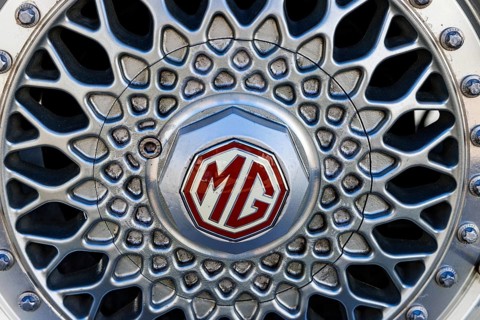 Alloy wheel with red and silver MG octagon badge on a classic MG sports car