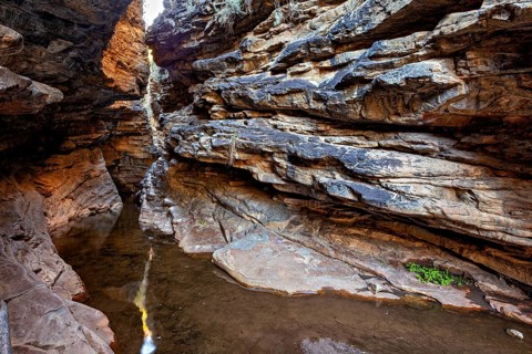 An area of a gorge with running water and a ray of light on the rocks, deep gorge in the spiny