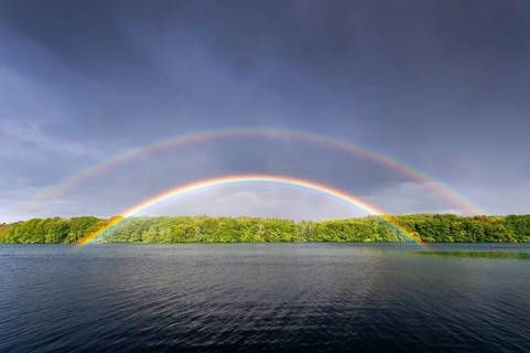 Colored rainbow over a lake, in Müritz National Park, Feldberger Seenlandschaft,
