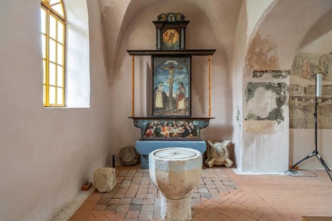 Baptismal font and altar in the interior of the fortified church in Cisnadie or Heltau,