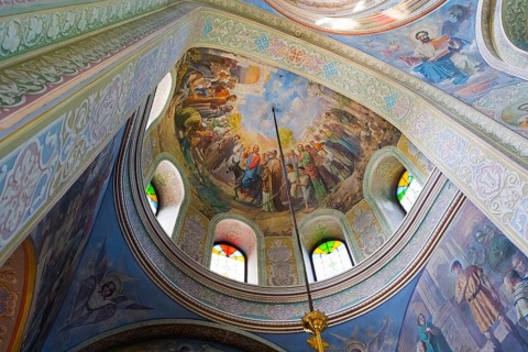 Ceiling of a dome in an Orthodox church with frescoes and stained glass windows, Capriana
