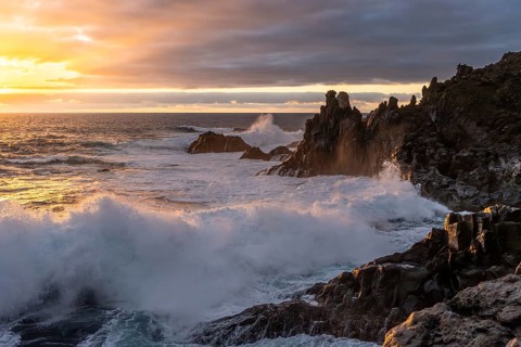 Waves break on the lava coast at sunset. Charco Verde, La Palma, Canary Islands, Spain
