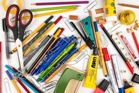A jumble of stationery and office supplies on a white surface