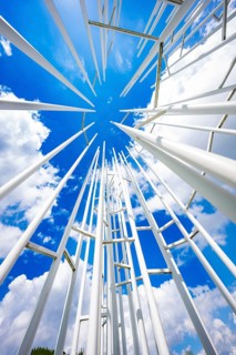 White poles rise up in an ornate pattern against a clear blue sky with clouds, Krumbach,