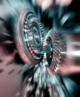 Close-up of precision spiral bevel gears in an industrial machine, showing intermeshing teeth and
