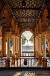 Framed view of Plaza de Espana Public Square in Seville, Spain, showing arched gallery, central