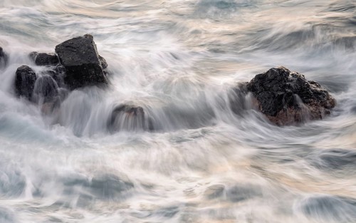 Rocks in the ocean, washed by waves. Long exposure, evening. Playa de Nogales, La Palma, Canary