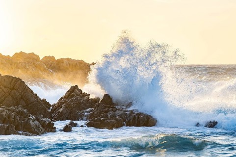 Braking waves at the coastline of Marinedda Coast at sunset, Sardinia, Italy