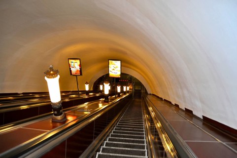 A long escalator in an illuminated tunnel leads down, metro, Saint Petersburg, St. Petersburg,