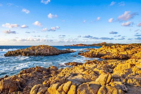 Landscape of the coastline with blue water at Marinedda Coast at sunset, Sardinia, Italy